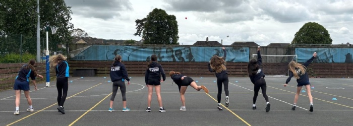 Honiton girls outside on court practicing cricket drills 